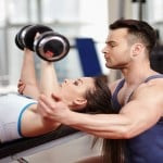 Personal trainer helping woman at gym